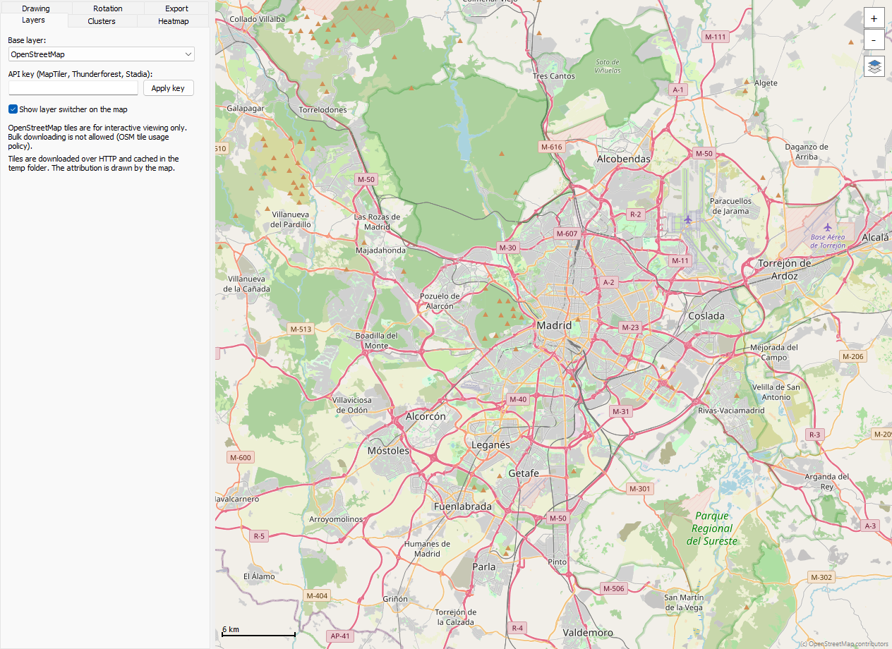 The MapFeatures demo with the base layer picker, API key box and layer switcher over a map of Madrid